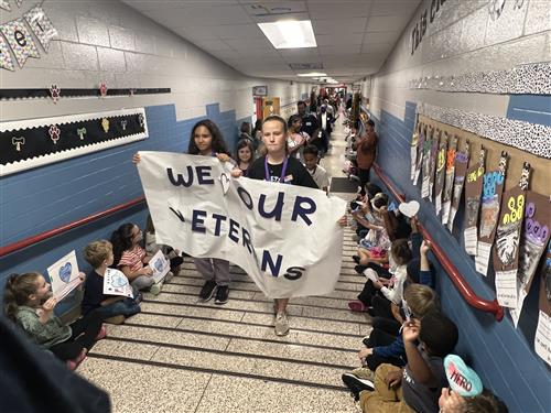 teachers leading procession of veterans down the halls of Madison Elementary